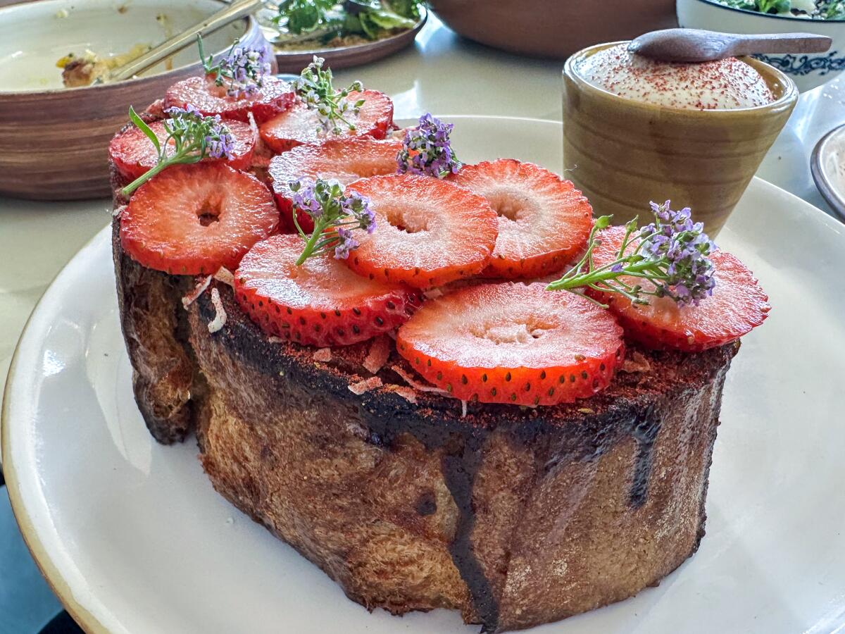 French toast, soaked in custard and crowned with strawberries, at Atelier Manna.