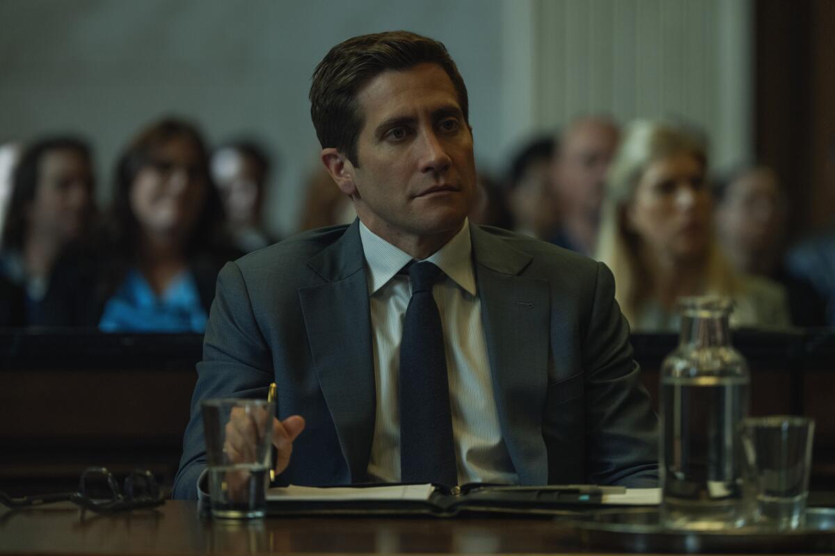 A criminal defendant in a suit sits in the courtroom during his trial.