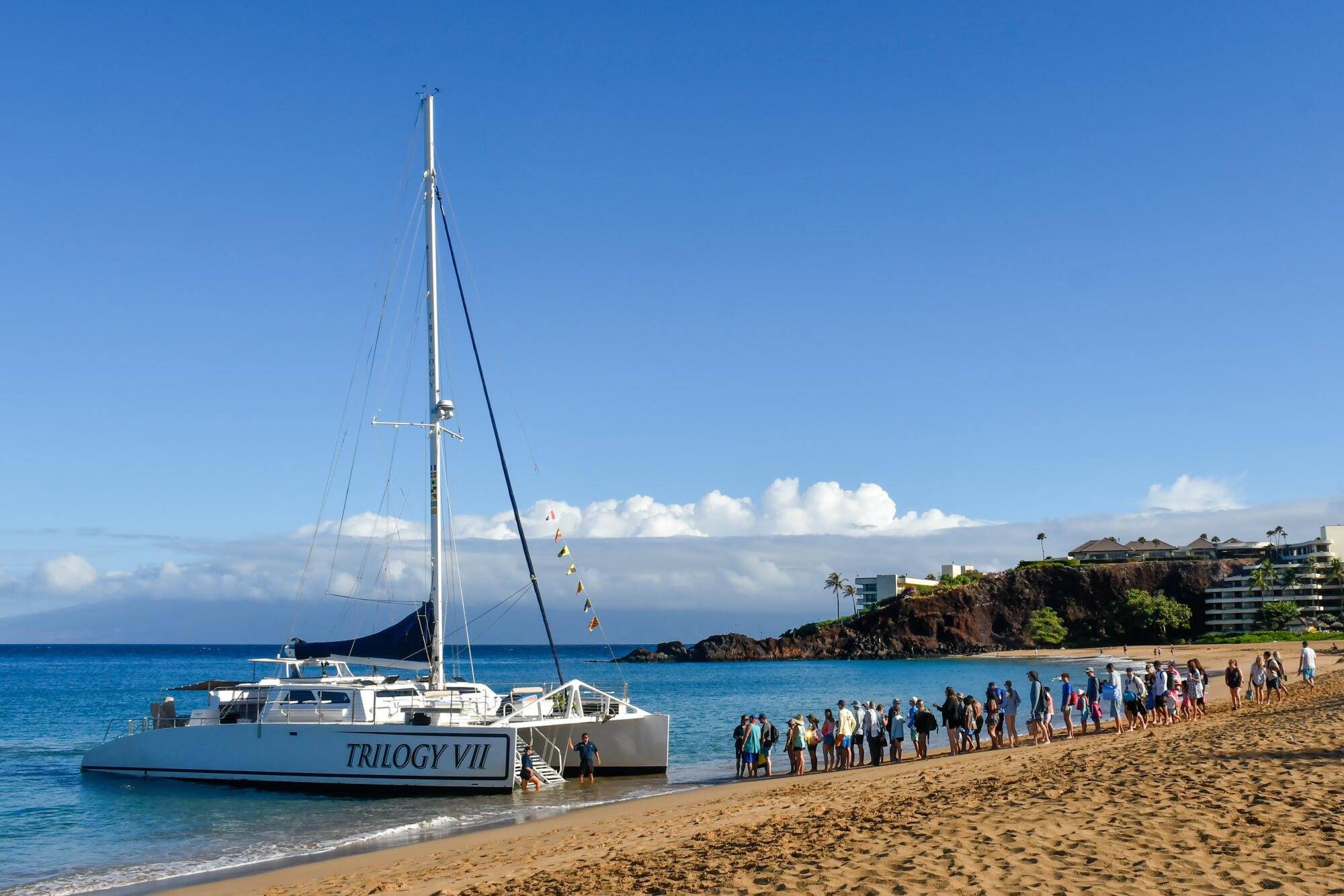 A catamaran waits on the shorefront