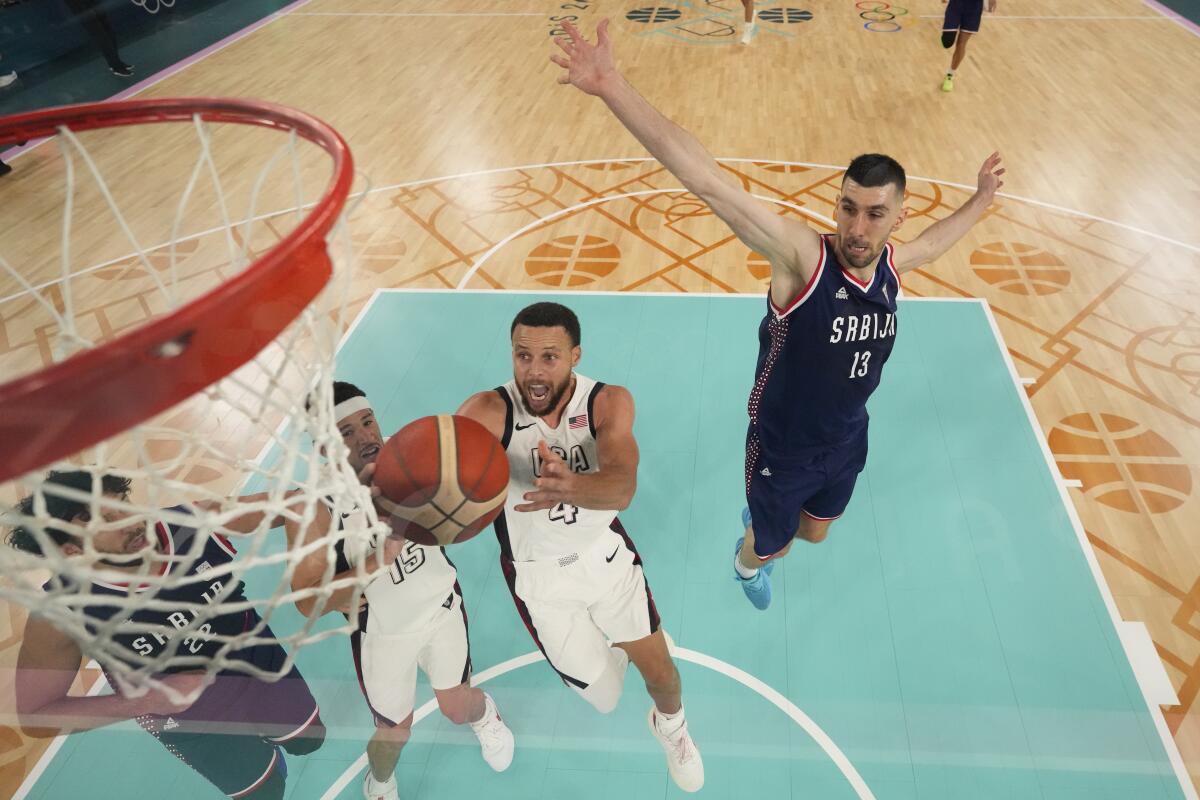 American Stephen Curry shoots past Serbia's Ognjen Dobric during a semifinal basketball game