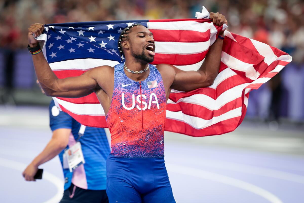 a man holding up the U.S. flag in celebration