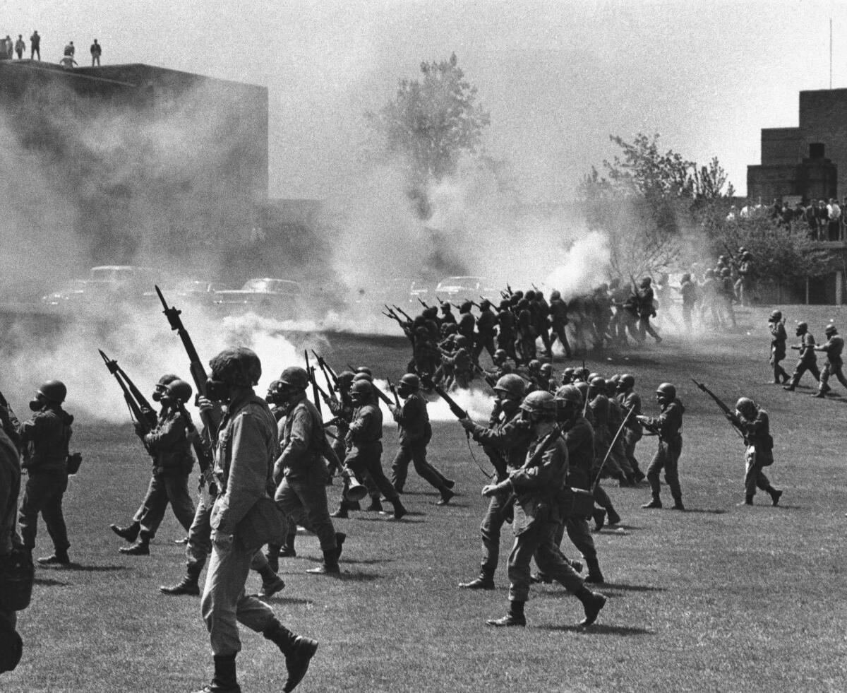 Armed soldiers march on a college campus.