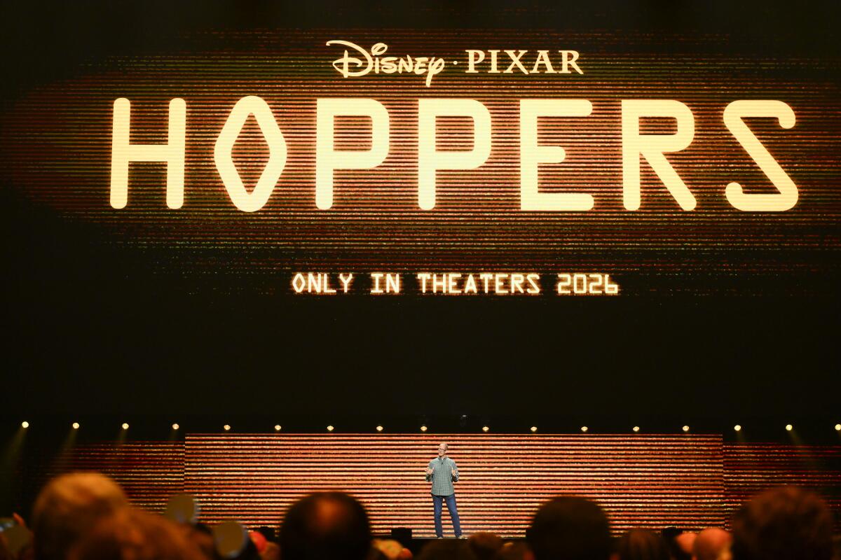 a man on stage standing under a logo for "Hoppers"