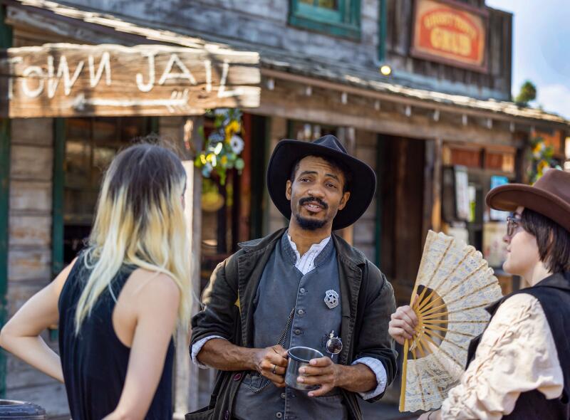 Visitors talk to Evan Battle, center, who plays Deputy Chester Davenport.