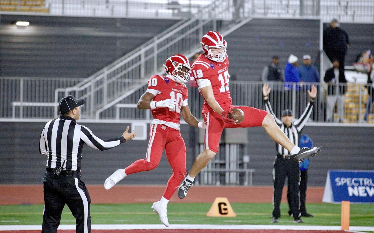 Mark Bowman (19) celebrates with Marcus Harris after after scoring Mater Dei’s first touchdown against San Mateo Serra.