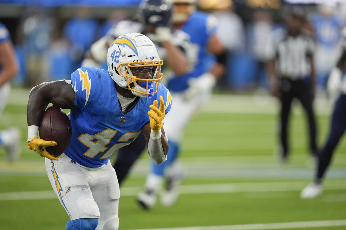 Chargers back Elijah Dotson (42) runs against the Seattle Seahawks during their preseason game.