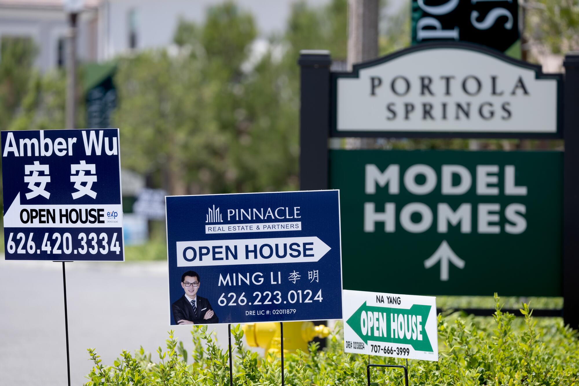 Signs posted by local Realtors at Portola Springs development in Irvine.