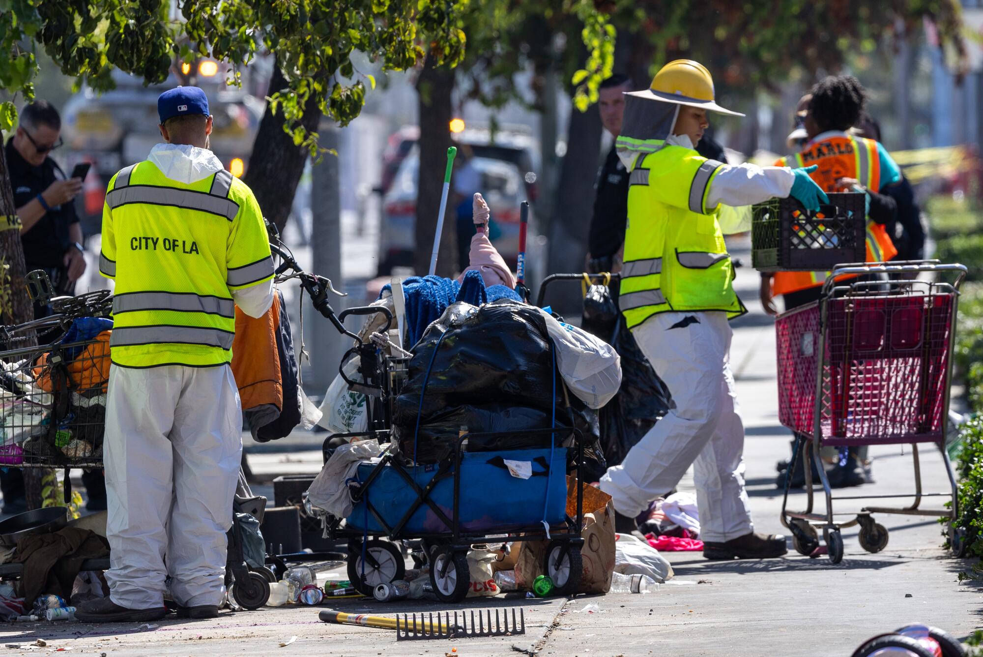 Sanitation workers clean up a homeless encampment