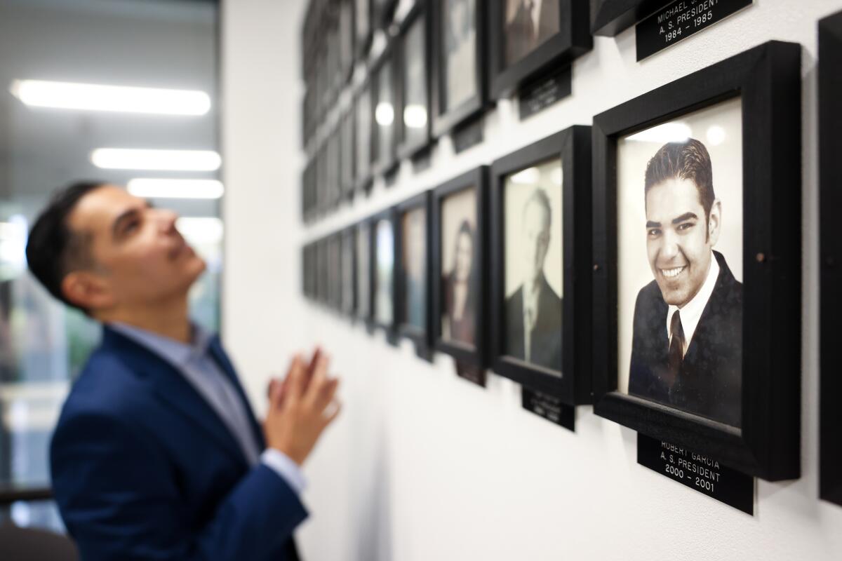 Rep. Robert Garcia finds his picture, right, amongst past student government presidents.