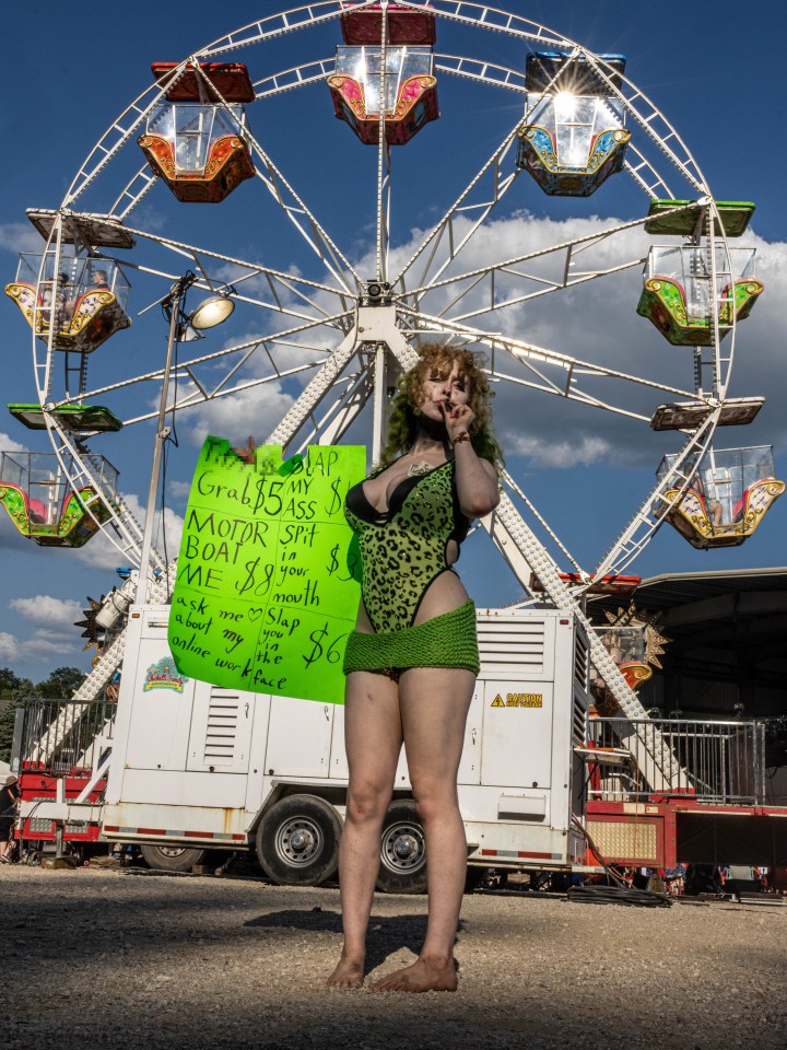 LouLou holds a sign that advertises a $6 face slap, among other offers