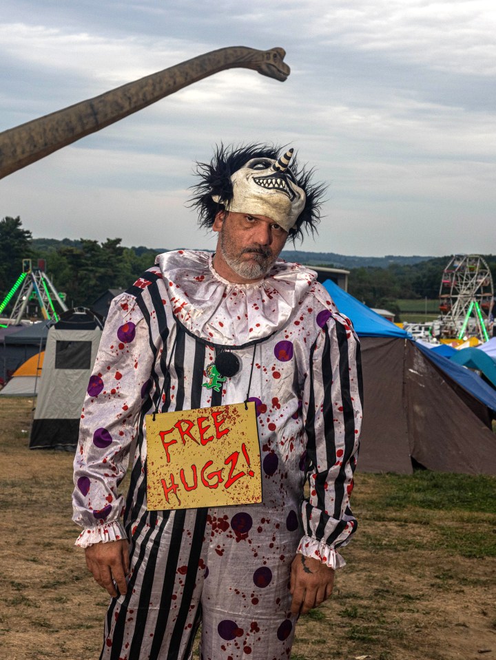 A Juggalo was dressed as a clown wearing a sign reading 'free hugz' around his neck