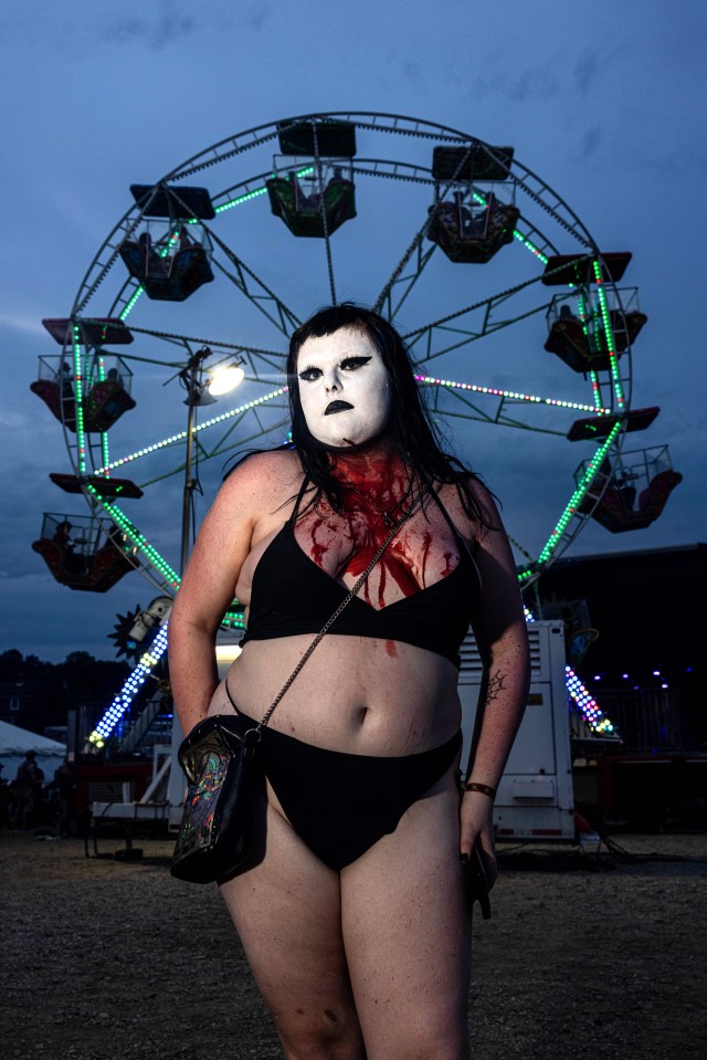 A Juggalette posed in a black bikini with white face paint and blood running down her chest