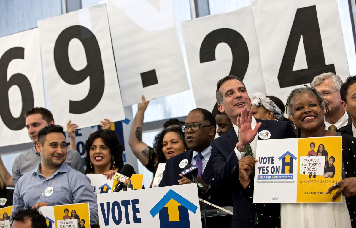 Several people gathered together with signs saying to vote.