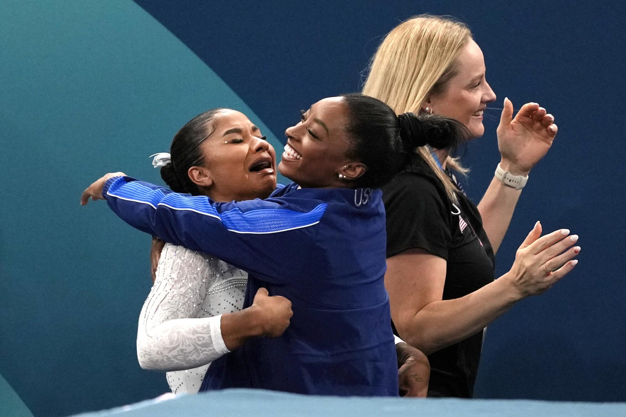 American Jordan Chiles gets a hug from teammate Simone Biles after realizing she won the bronze medal 