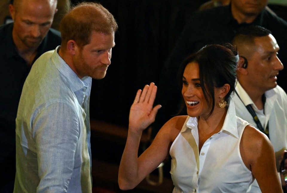 The Duchess of Sussex waves to crowds on arrival in Cali