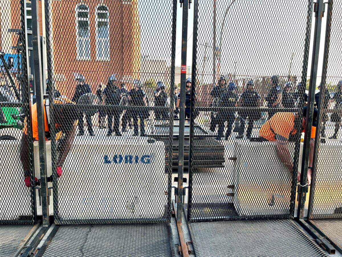 Chicago police hammer a metal barricade back into place after protesters broke through, causing a scuffle with police. 