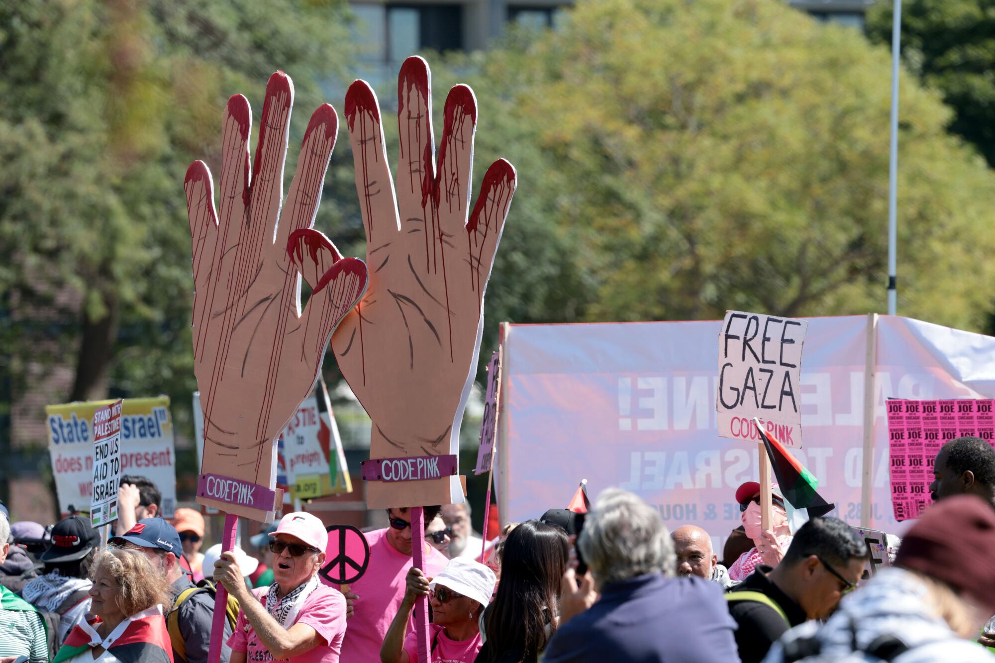 Protesters in Chicago hold poster cutouts of bloody hands and a "Free Gaza" sign.