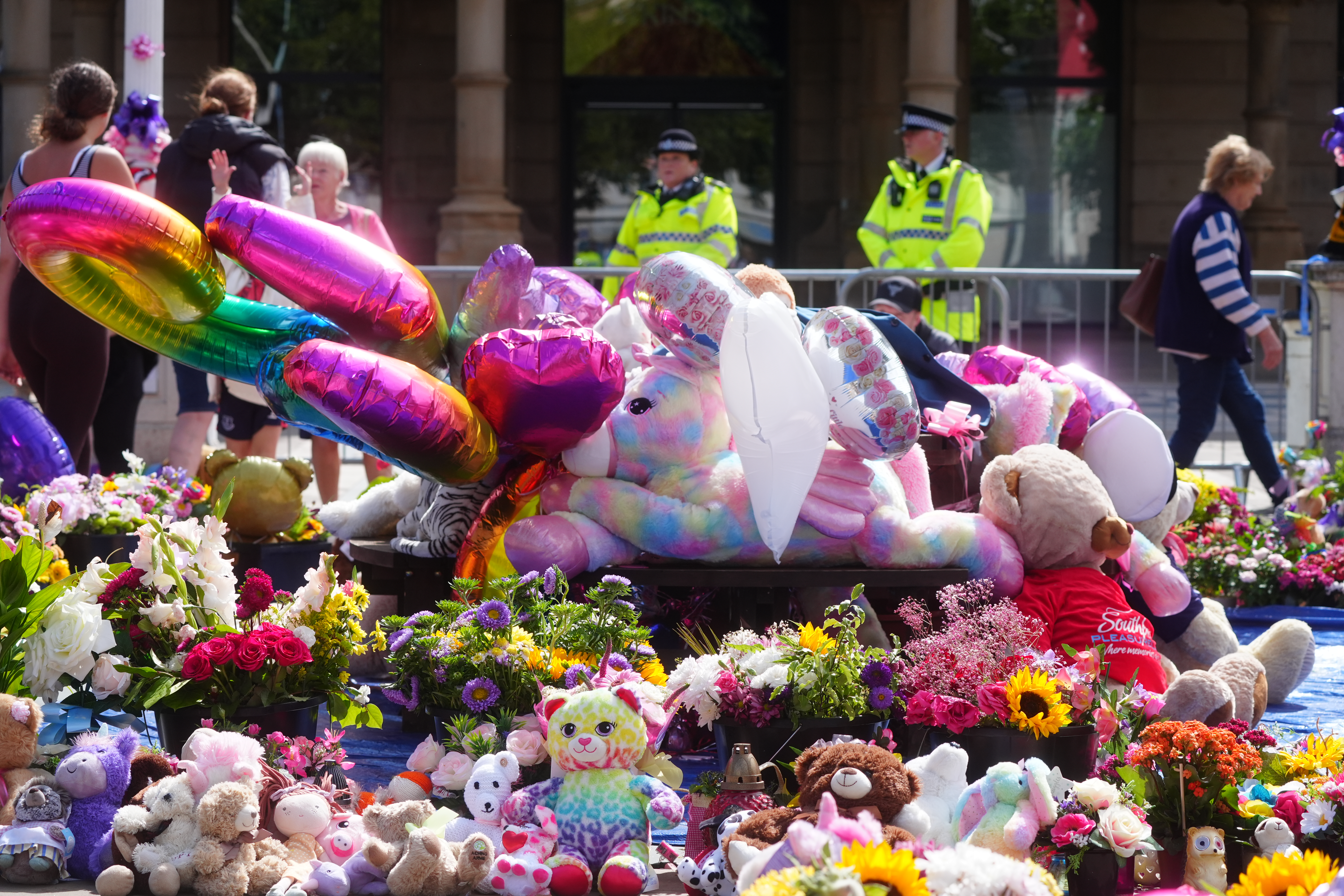 Balloons, flowers and cuddly toys have been laid out in memory of the three children who died following the attack