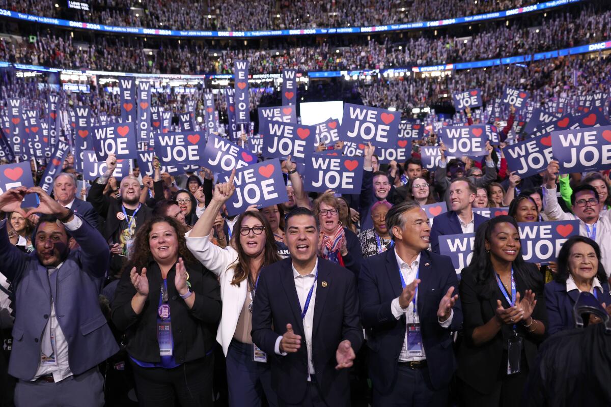 Rep. Robert Garcia, center, along with the California delegates cheer President Biden at the Democratic National Convention. 