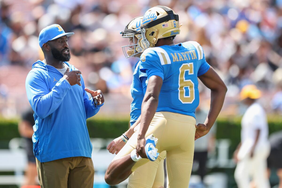 UCLA coach DeShaun Foster talks with quarterbacks Justyn Martin and Ethan Garbers during the spring game on April 27.