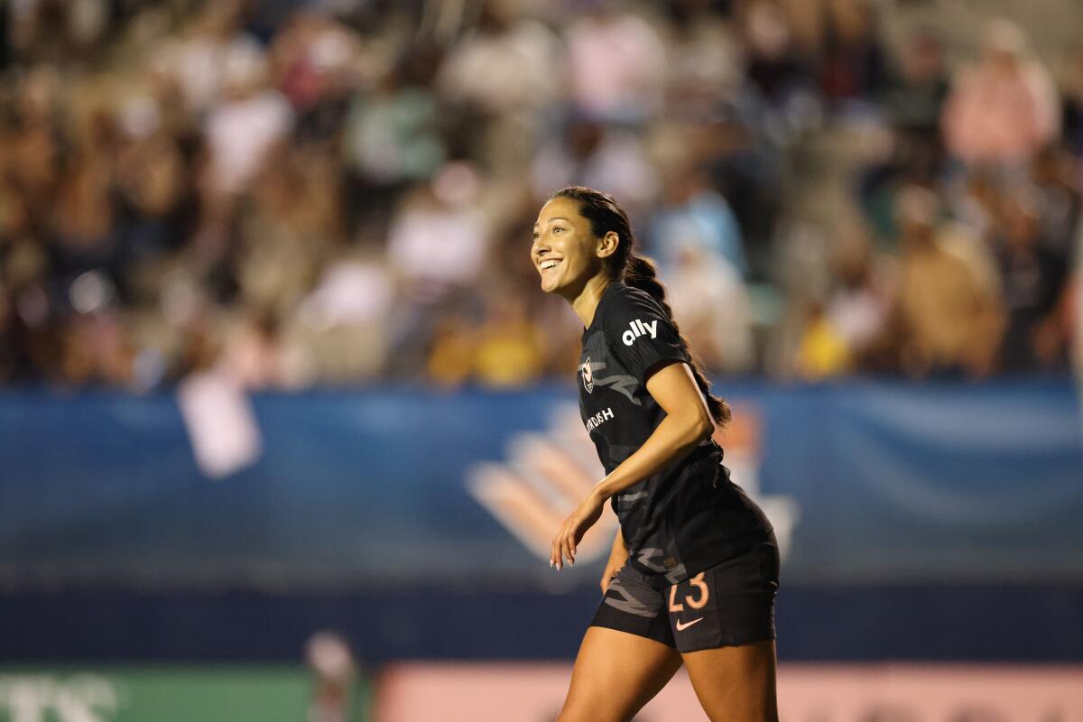 A soccer player smiles as she takes the field 