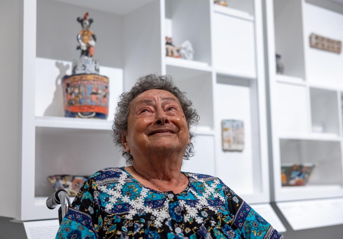 Artist Magdalena Suarez Frimkess, 95, looks up from her wheelchair with a big smile.