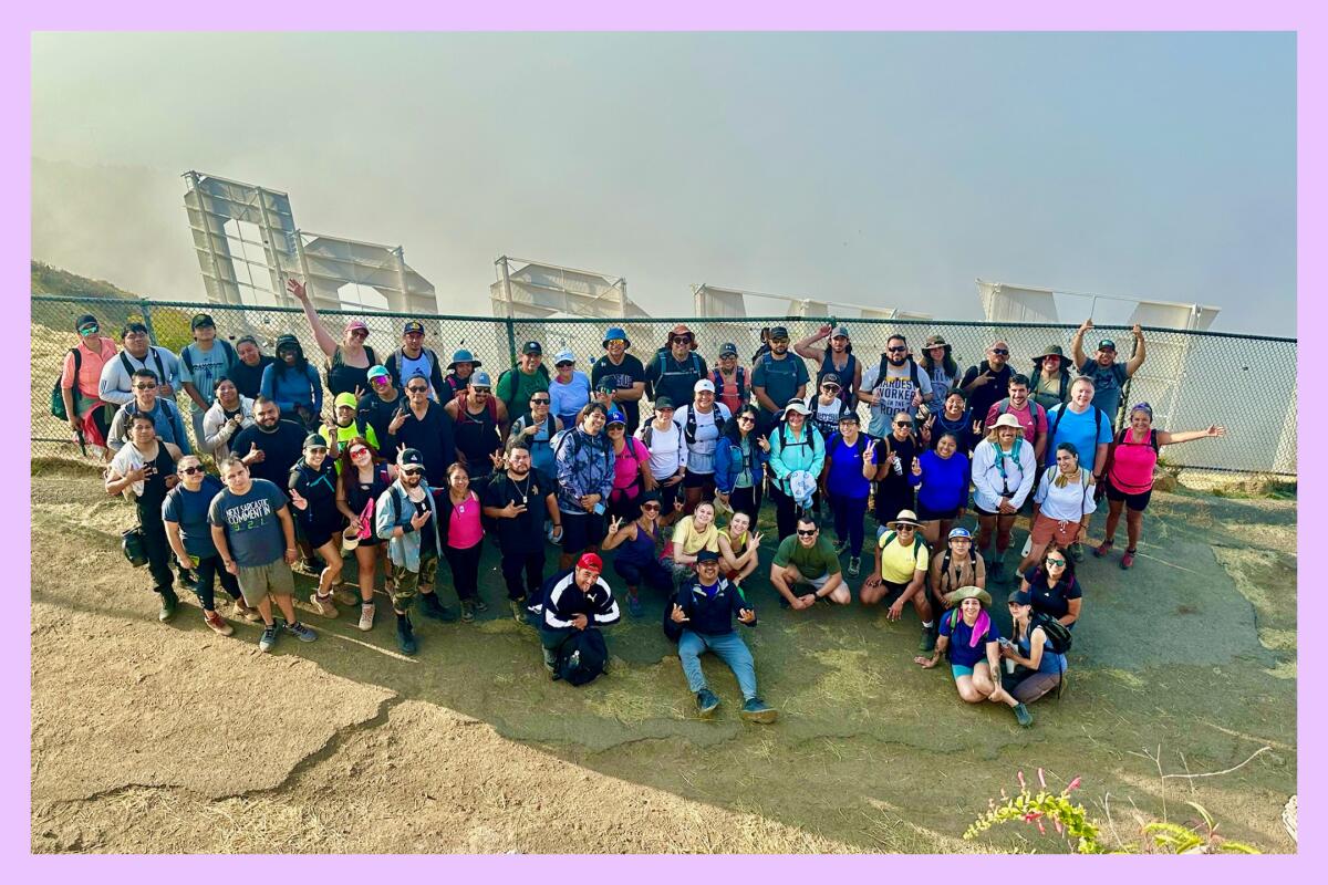 The 5 AM Crew poses behind the Hollywood sign on Mt. Lee in Griffith Park. Morning fog hides the view in the distance.