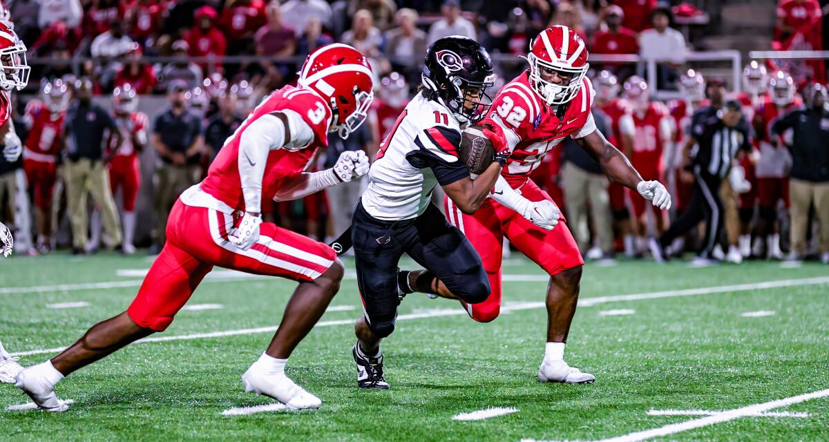 Linebackers Nasir Wyatt, left, and Abduall Sanders of Mater Dei prepare to take down Corona Centennial's Tyler George.