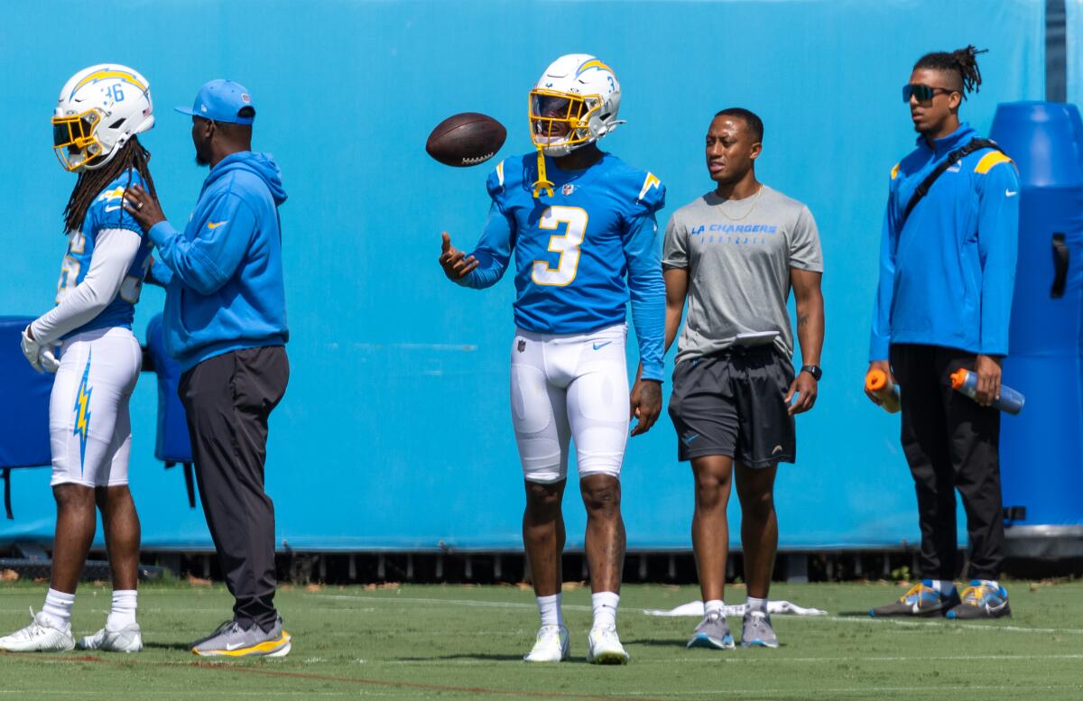 Chargers safety Derwin James Jr. flips a football on the sideline.