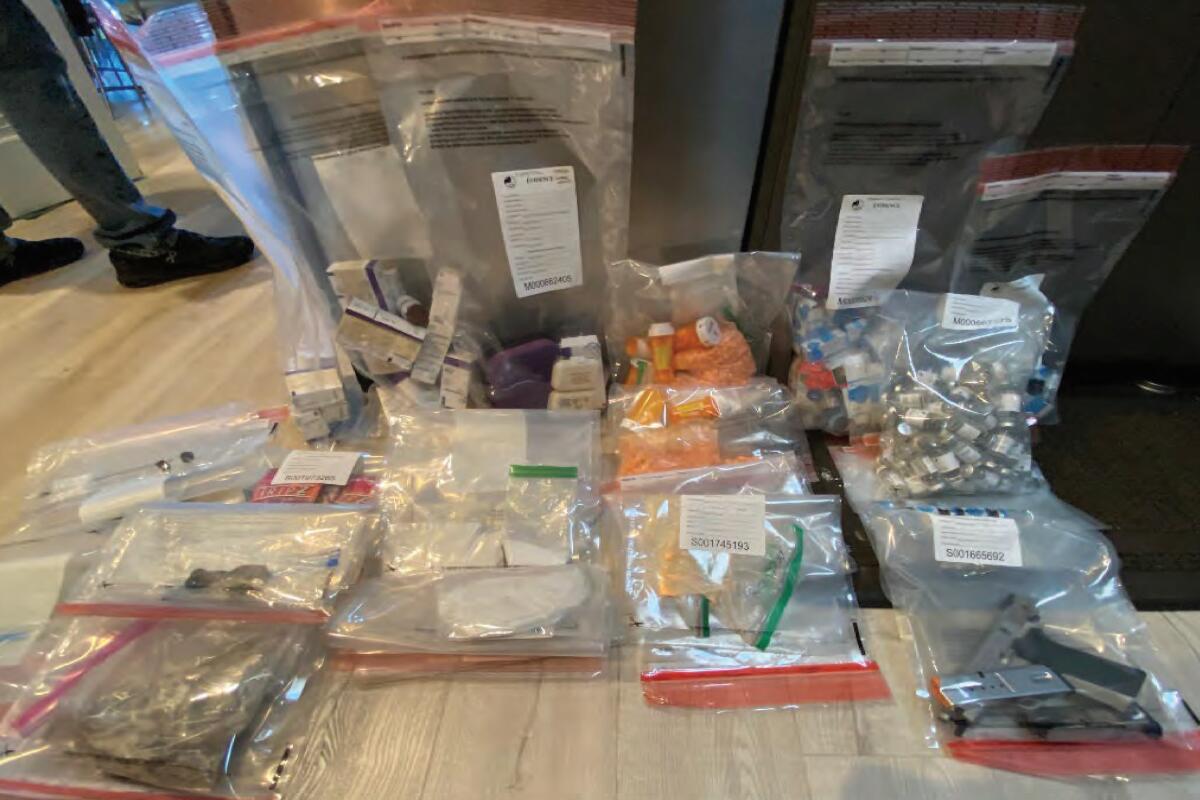 Clear plastic bags filled with evidence are displayed on a table.