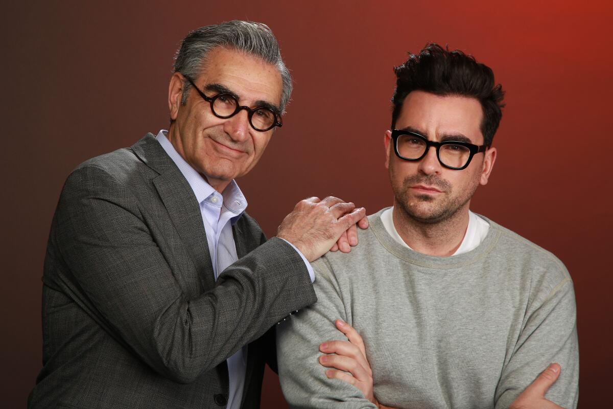 Eugene Levy rests his hands on son Daniel's shoulder for a portrait.