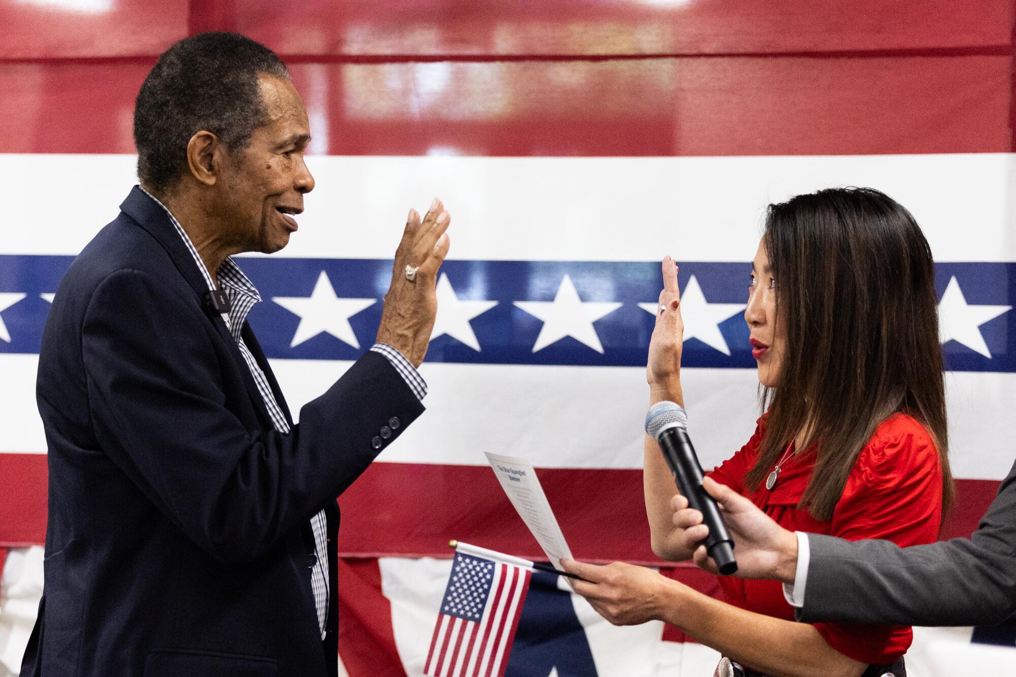 Former Angels star Rod Carew, left, is sworn in by Alanna Ow, USCIS San Diego District Director.