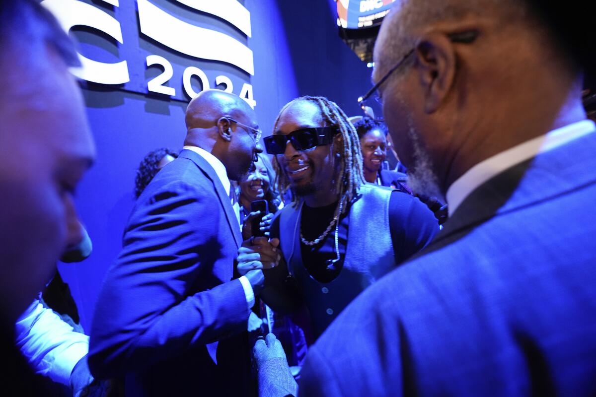 Lil Jon clasping hands with Sen. Raphael Warnock.