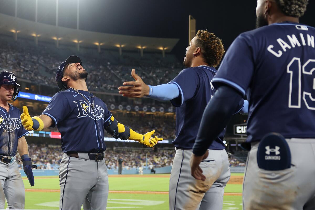 Tampa Bay's Jose Caballero celebrates with teammates after hitting a two-run home run off Dodgers reliever Joe Kelly.