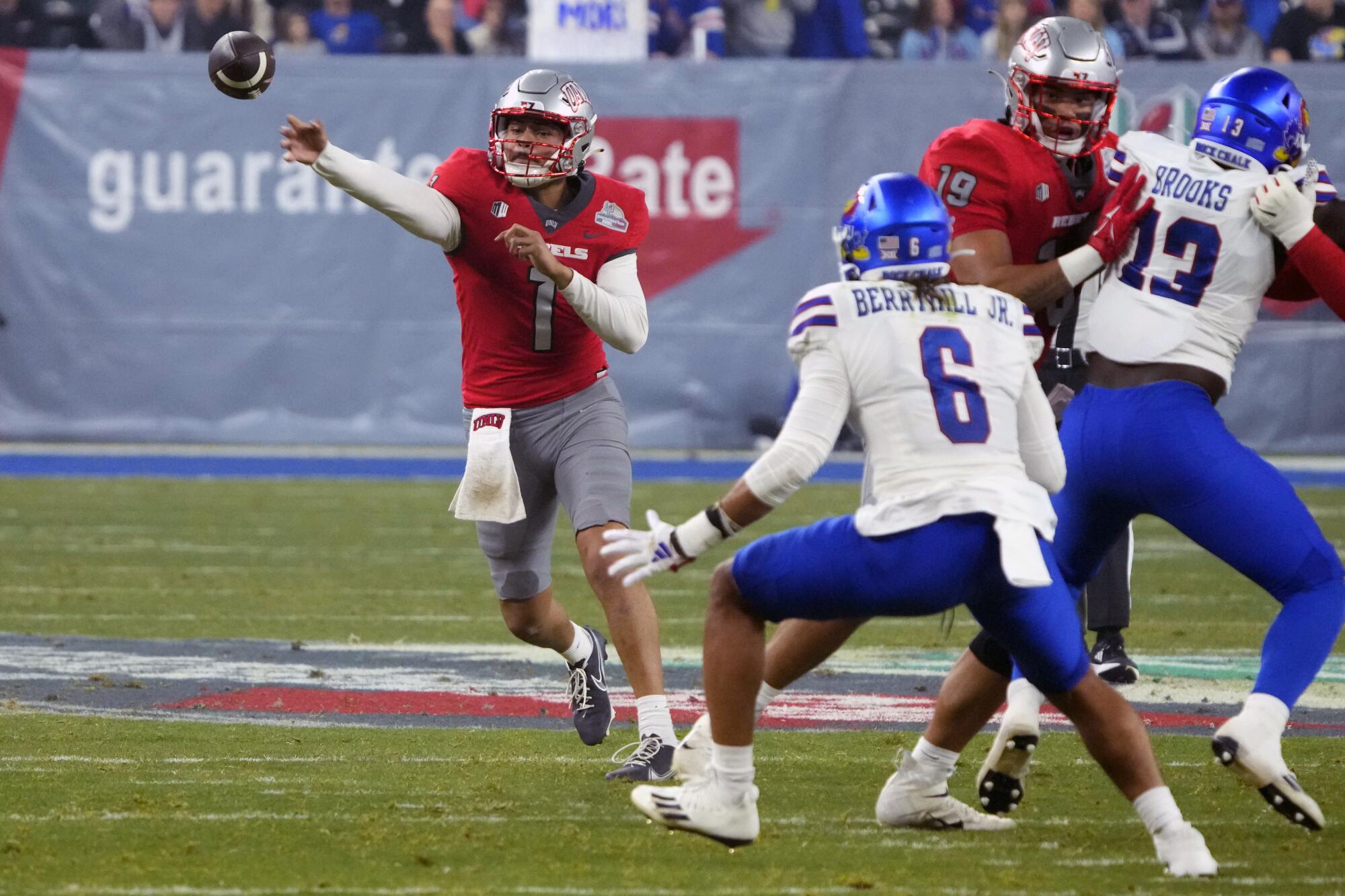 Jayden Maiava, left, throws past Kansas linebacker Taiwan Berryhill Jr. (No. 6) during the Guaranteed Rate Bowl in December.