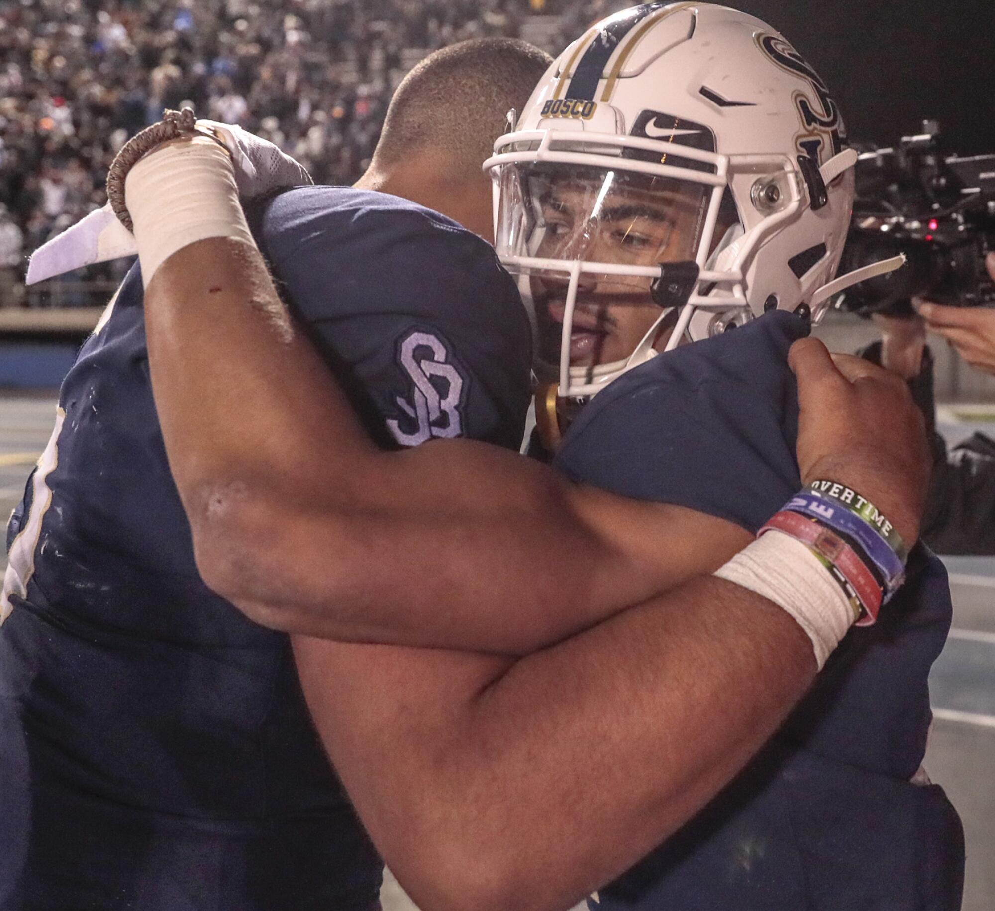 St. John Bosco receiver Kristopher Hutson hugs teammate DJ Uliagelelei.