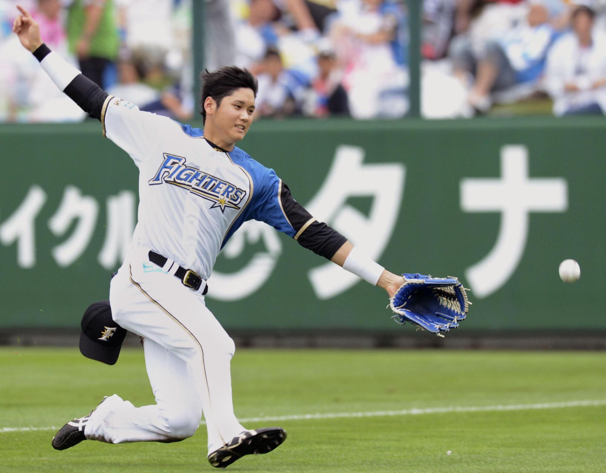 Nippon Ham Fighters outfielder Shohei Ohtani slides to make a catch during a game in August 2013. 