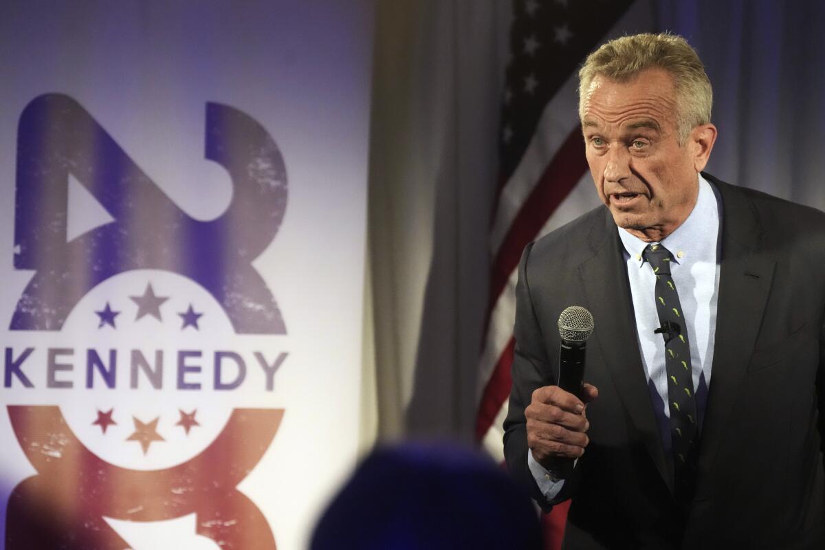 Robert F. Kennedy Jr.  wears a suit and speaks into a microphone