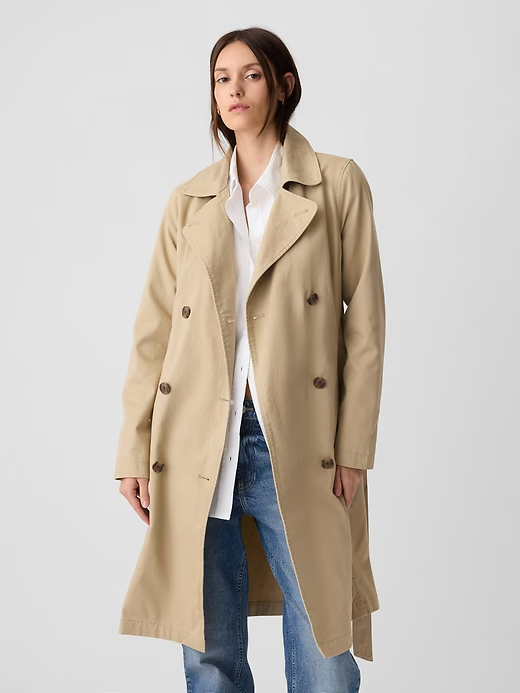 The Gap Modern Trench Coat features a notch lapel collar, a double-breasted button front, and a belt that ties at the waist