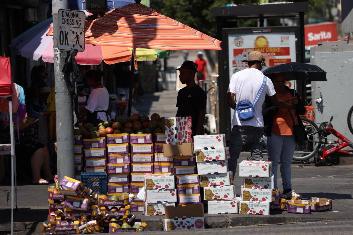 A street vendor with stacks of produce.