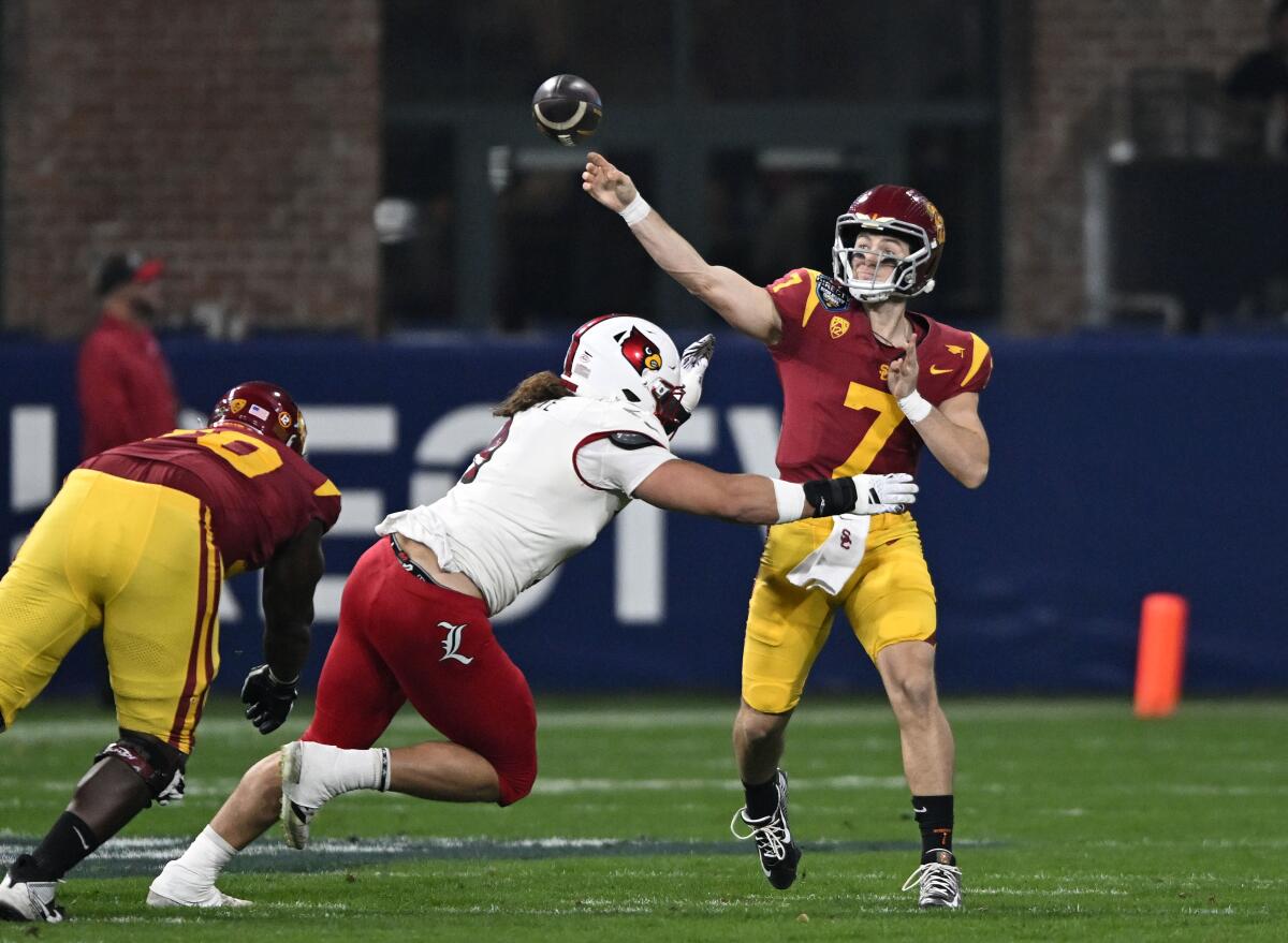 USC quarterback Miller Moss throws a pass under pressure from Louisville defensive lineman Ashton Gillotte 