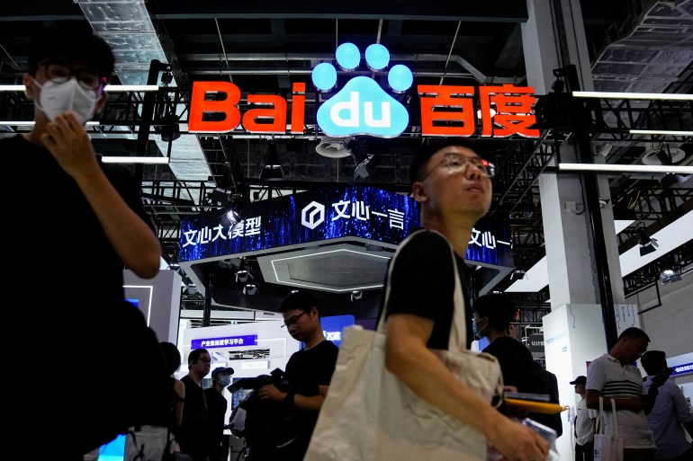 A Baidu booth at an AI conference in China. There is a big illuminated logo and people are milling around.