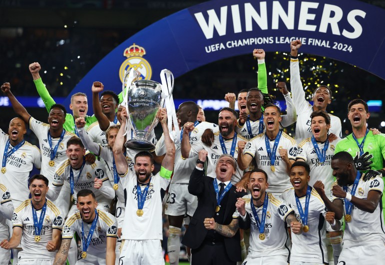 Real Madrid's Dani Carvajal lifts the trophy as he celebrates with teammates after winning the Champions League