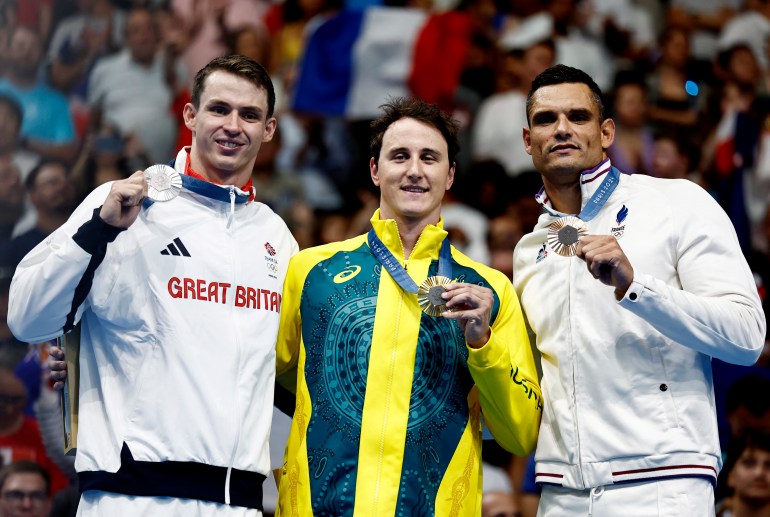 Paris 2024 Olympics - Swimming - Men's 50m Freestyle Victory Ceremony - Paris La Defense Arena, Nanterre, France - August 02, 2024. Gold medallist Cameron McEvoy of Australia celebrates on the podium with silver medallist Benjamin Proud of Britain and bronze medallistFlorent Manaudou of France. REUTERS/Clodagh Kilcoyne