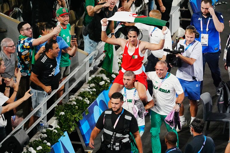 Aug 9, 2024; Paris, France; Imane Khelif (ALG) is carried on the shoulders of her corner team after victory over Yang Liu (CHN) in a women’s 66kg gold medal bout during the Paris 2024 Olympic Summer Games at Stade Roland Garros. Mandatory Credit: Andrew P. Scott-USA TODAY Sports