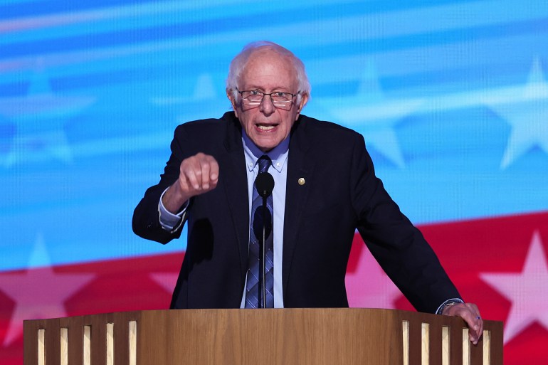 a man speaks at a podium in front of a blue and red background