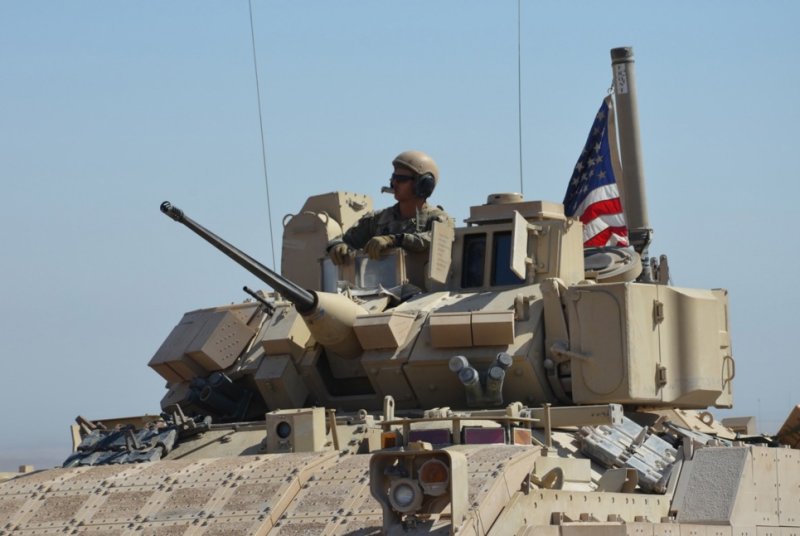 A U.S. soldier sits on top of a Bradley Fighting Vehicle during military exercises with Syrian democratic forces near the tri-border between Syria, Iraq, and Turkey on Sept. 7, 2022. U.S. Central Command said Friday seven U.S. soldiers were wounded and 15 Islamic State militants were killed during an battle in western Iraq. File Photo by Ahmed Mardnl/EPA-EFE