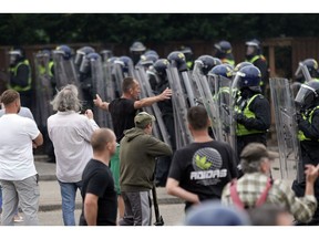 Riot police clash with anti-migration protesters outside of a Holiday Inn Express in Manvers, UK, that's being used as an asylum hotel, on Aug. 4.