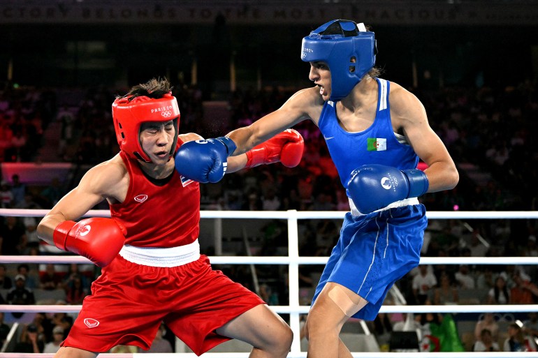 Thailand's Janjaem Suwannapheng and Algeria's Imane Khelif (Blue) compete in the women's 66kg semi-final boxing match during the Paris 2024 Olympic Games at the Roland-Garros Stadium, in Paris on August 6, 2024. (Photo by MOHD RASFAN / AFP)