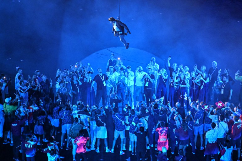 US' actor Tom Cruise descends from the roof of the stadium during the closing ceremony of the Paris 2024 Olympic Games at the Stade de France, in Saint-Denis, in the outskirts of Paris, on August 11, 2024. (Photo by MOHD RASFAN / AFP)